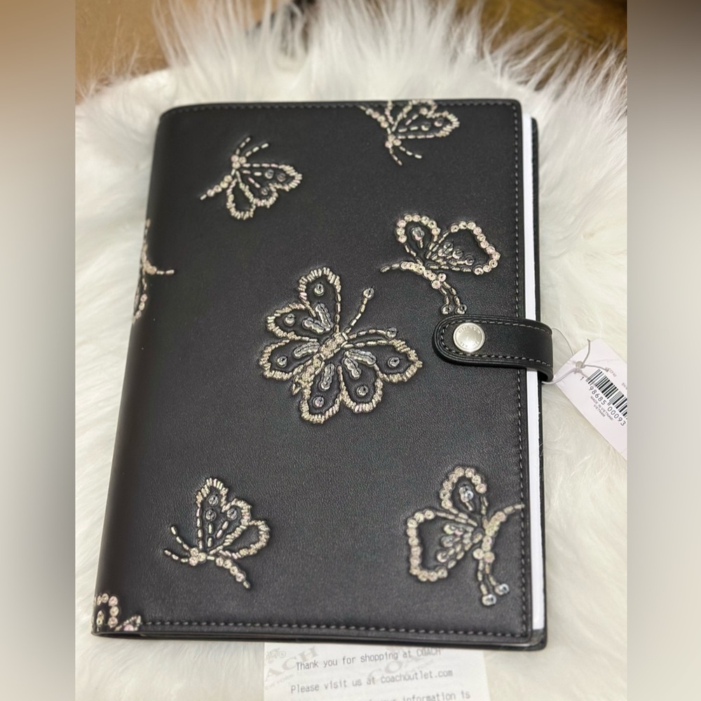 Coach Butterfly Print Notebook In black with sequins.